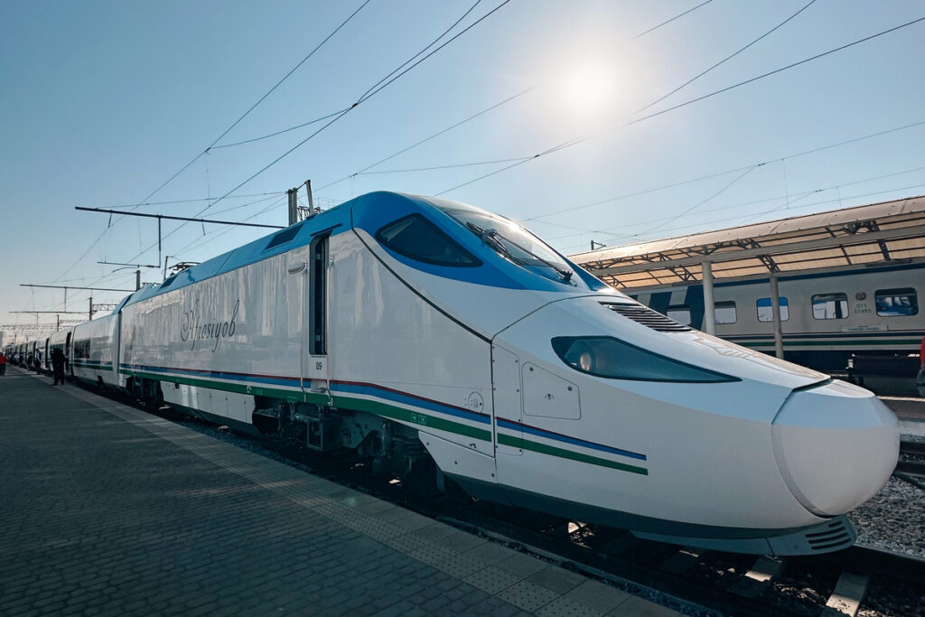 The white and blue Afrosiyob high-speed train standing at a station platform in Uzbekistan.