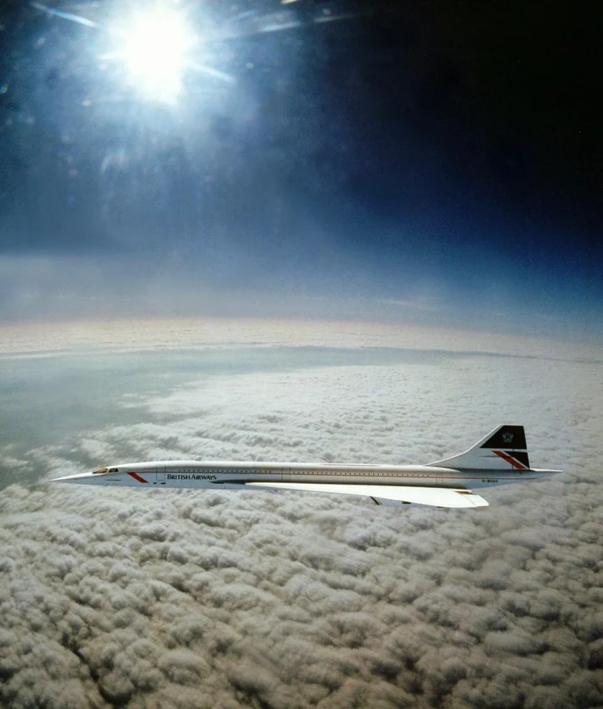 British Airways Concorde G-BOAG flies above a cloud deck beneath a dark blue sky during an April 1985 air-to-air session.