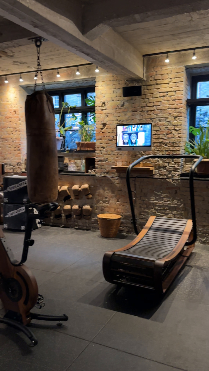 A curved wooden treadmill, punching bag and dumbbells in the gym at Bryggen Guldsmeden