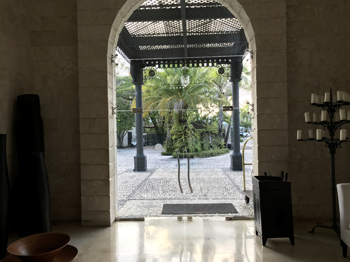 Arched glass entrance and shaded driveway at Casa Colonial