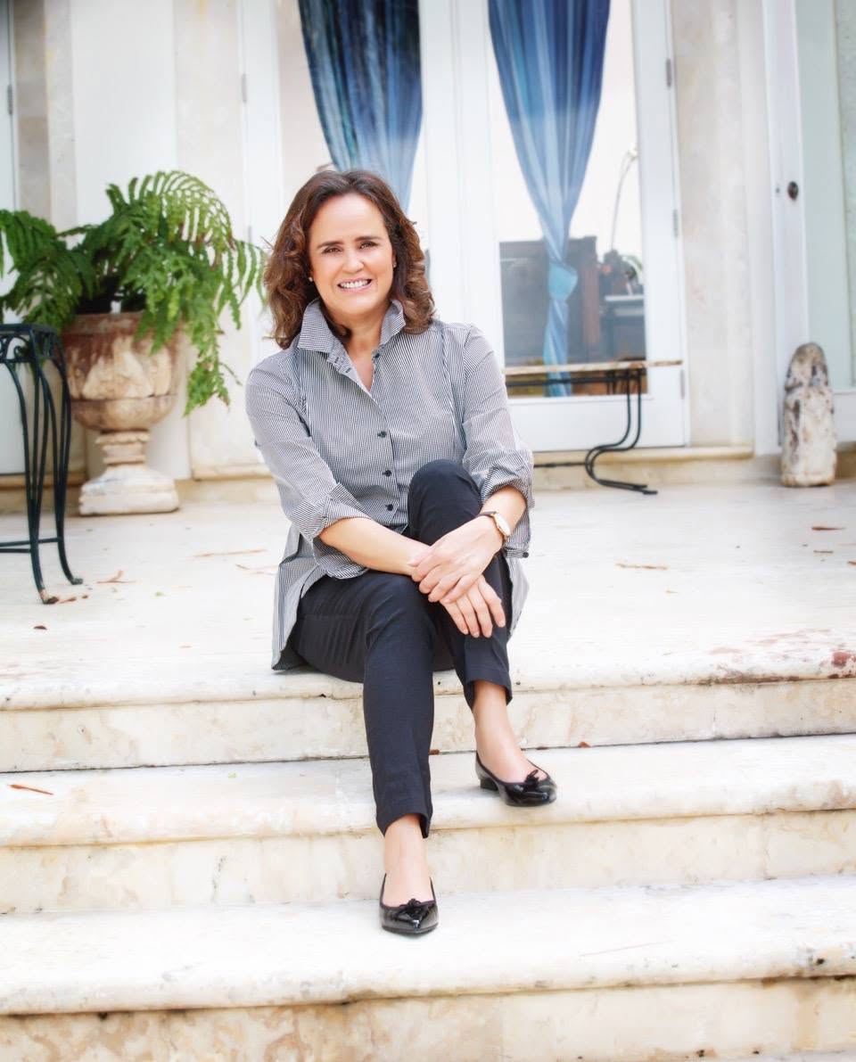 Sarah García seated on stone steps outside Casa Colonial