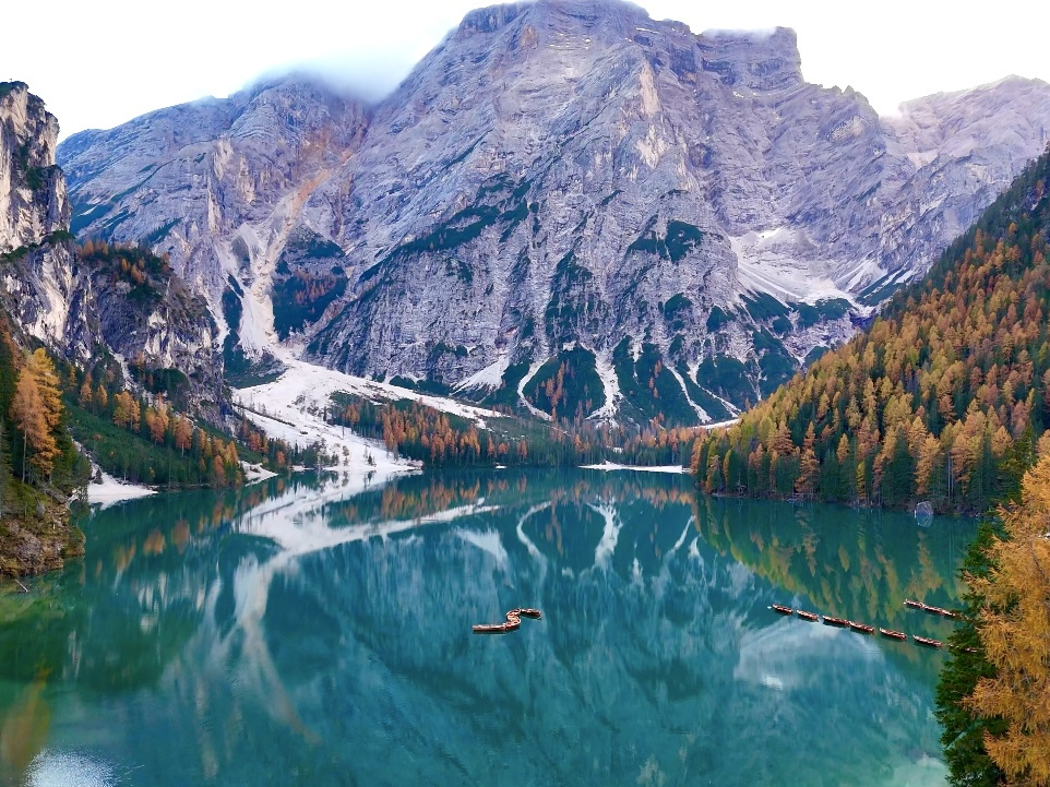 Turquoise Lago di Braies reflects the sheer mountain walls and golden larches around its shore.