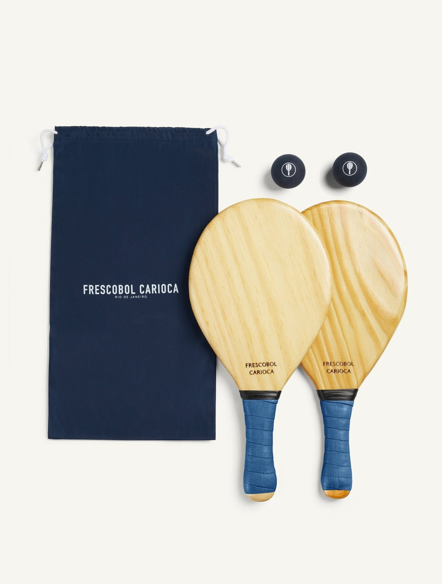 Two Barra Classic bats and two balls beside a navy Frescobol Carioca carry sack.