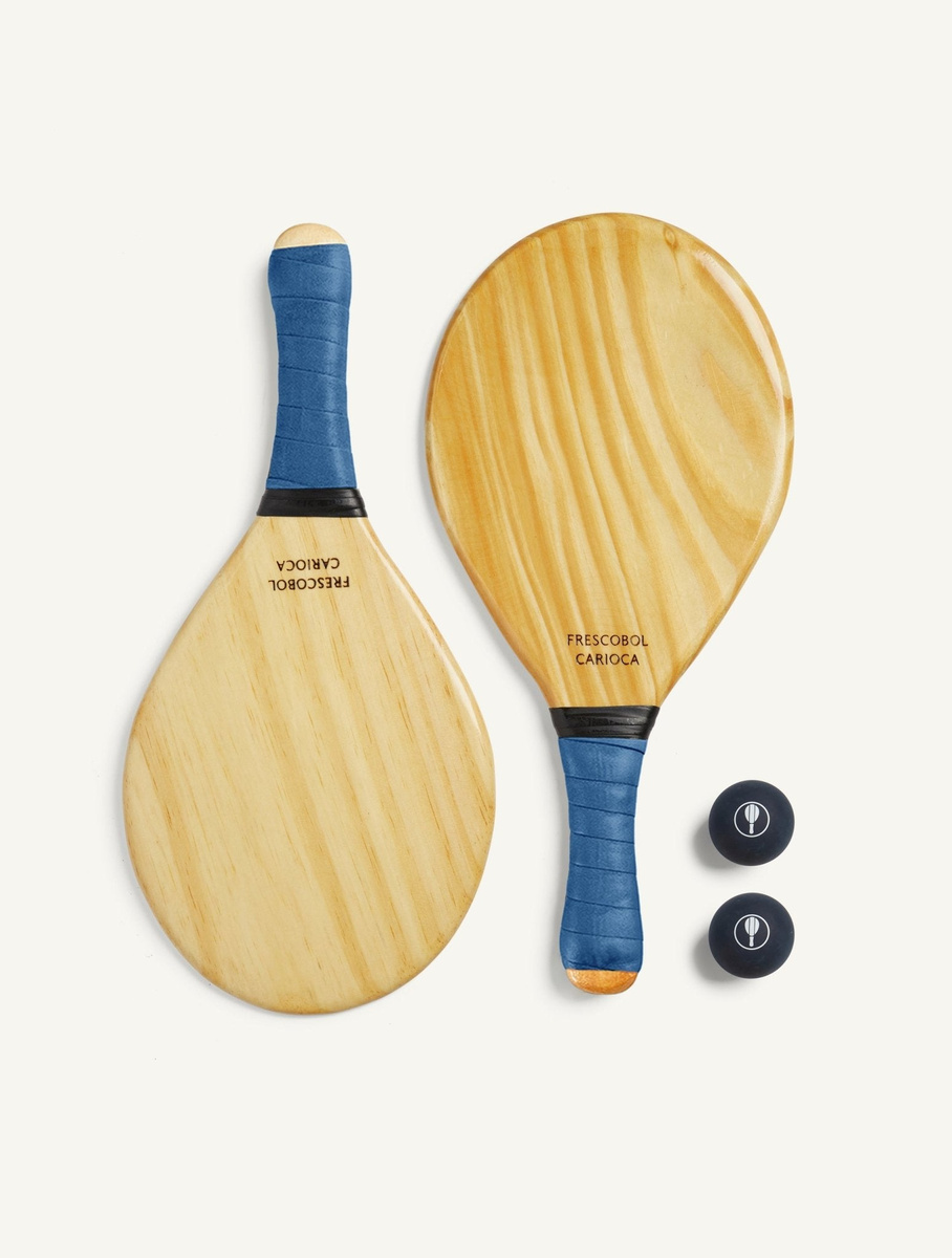 Two Frescobol Carioca pine beach bats with blue grips and two navy balls.