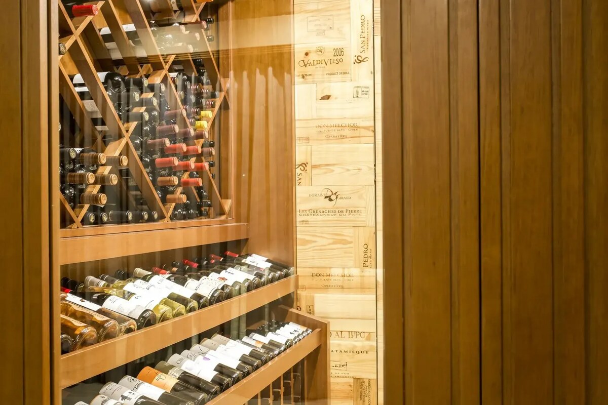 Wine bottles stacked in diagonal wooden racks in the hotel’s wine cellar.