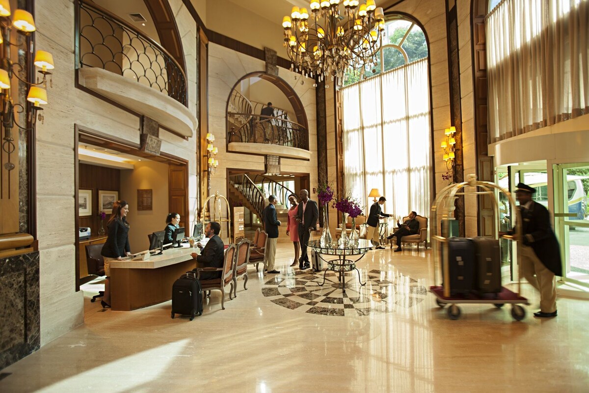 The double-height lobby of Gran Estanplaza Berrini, with a crystal chandelier, curved balconies and the reception desk.