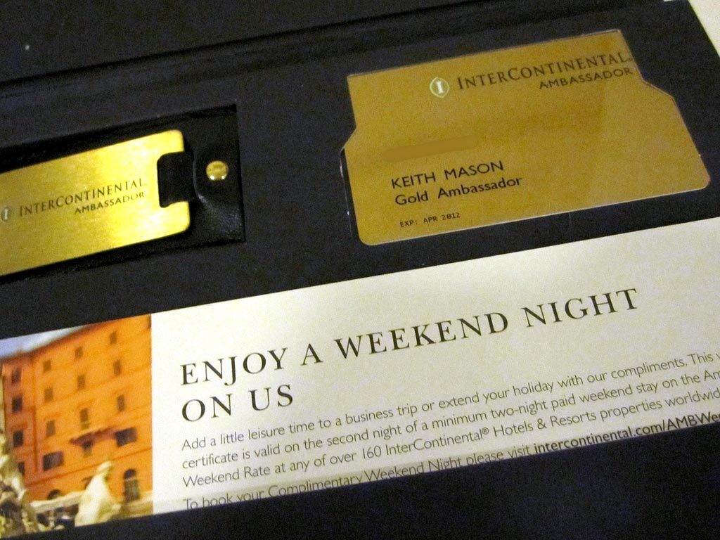 A gold InterContinental Ambassador card and matching gold luggage tag sit in a black presentation box above a weekend-night voucher.