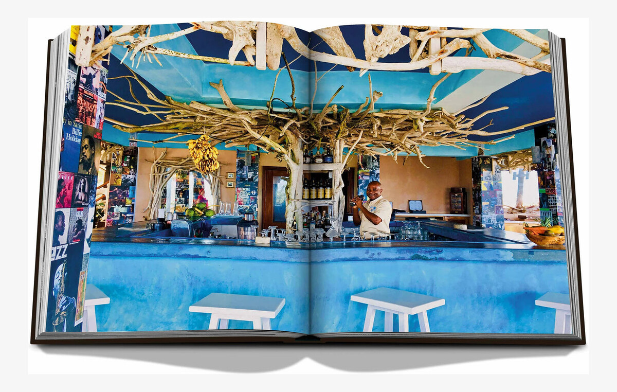 An open spread showing a bright blue bar decorated with branches, bottles and hanging ornaments.
