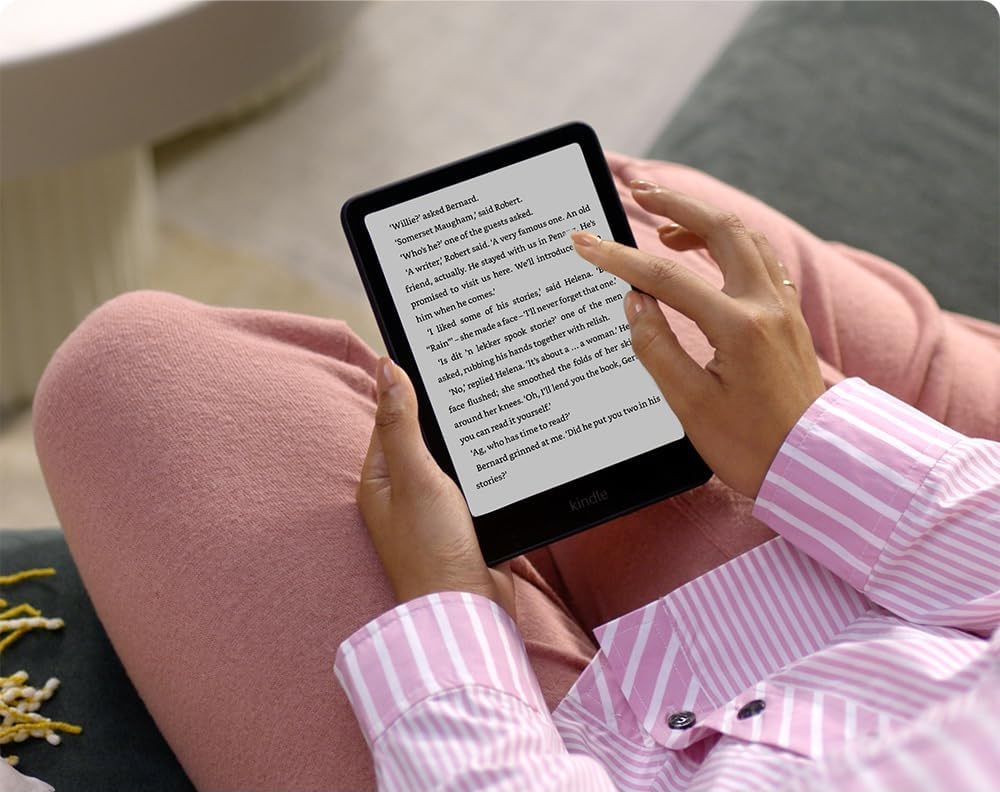 A reader turning a page on a Kindle Paperwhite.