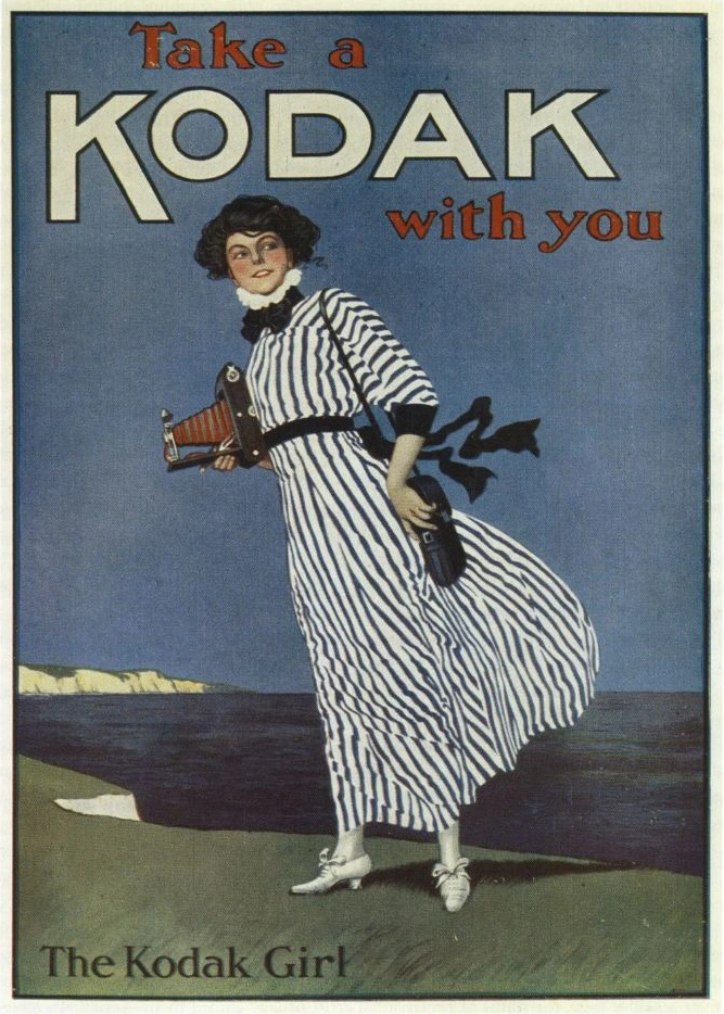 John Hassall poster showing a woman in a striped dress carrying a folding camera beside the sea, beneath the words Take a Kodak with you.