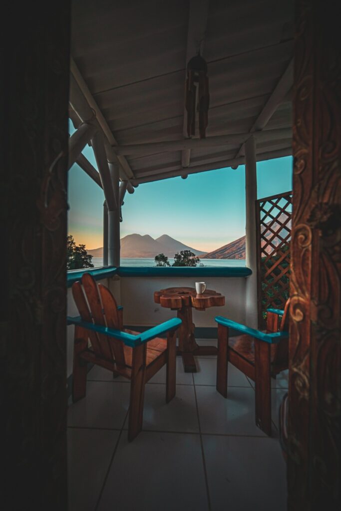 Two wooden chairs and a small table on a terrace facing Lake Atitlán