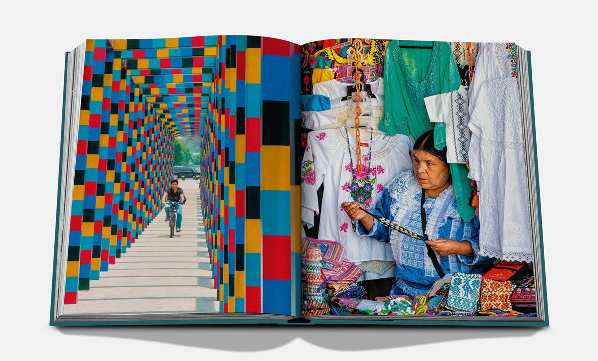 An open spread with a vividly coloured geometric passageway and a person working beside embroidered textiles.