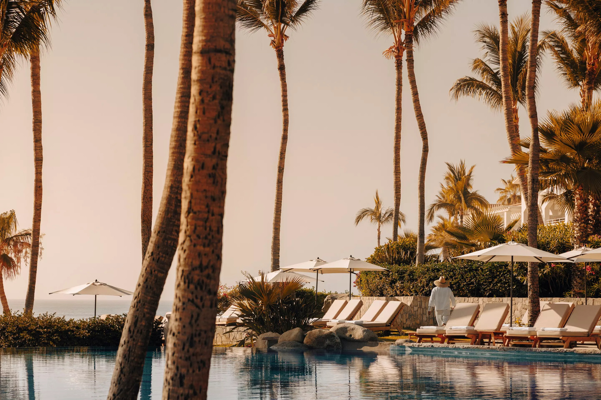 Pool, sun loungers and palms at One&Only Palmilla in warm evening light.