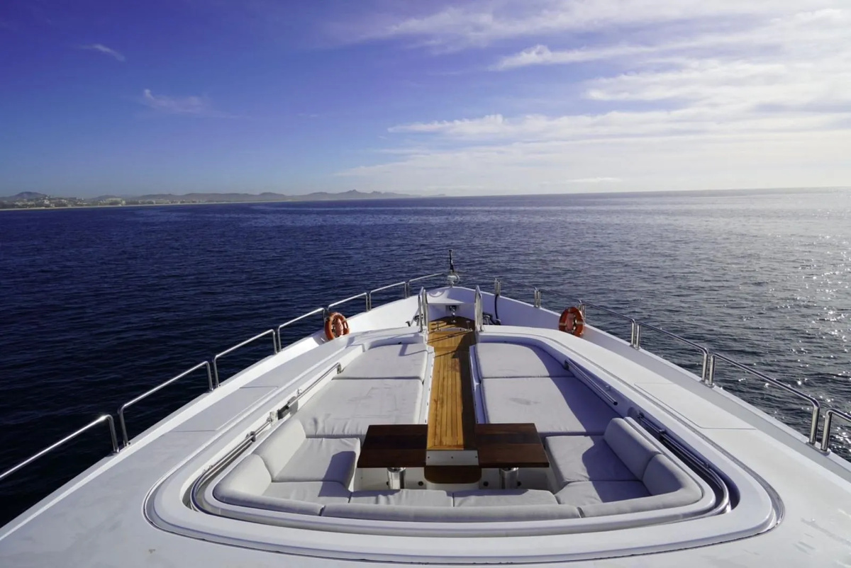 Empty wraparound seating and sunpads on GO’s foredeck, looking out to sea.