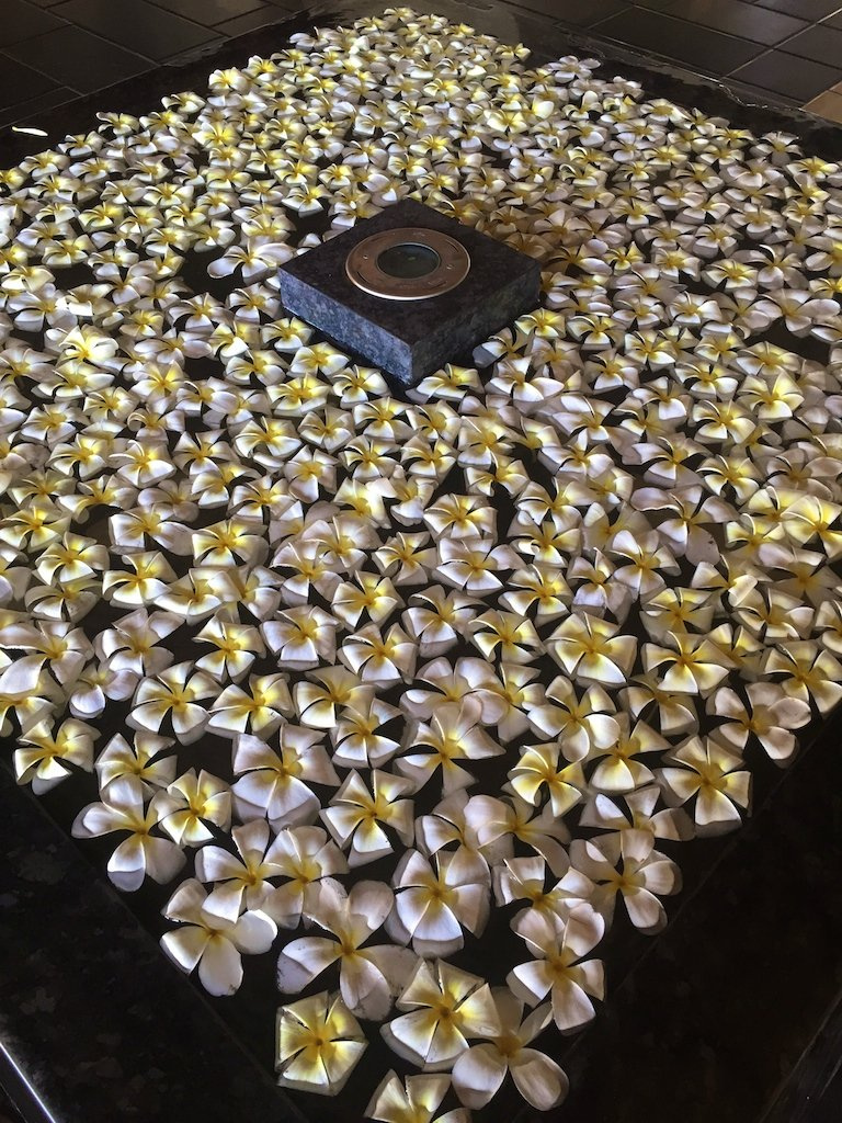 White frangipani flowers arranged around a fountain at The Ritz-Carlton, Bali