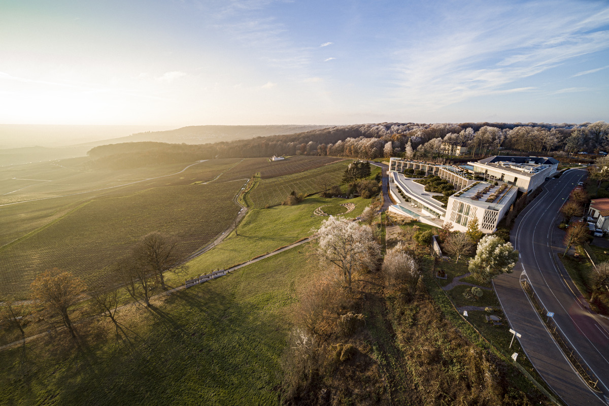 Aerial view of Royal Champagne above vineyards, with terraces following the hillside.