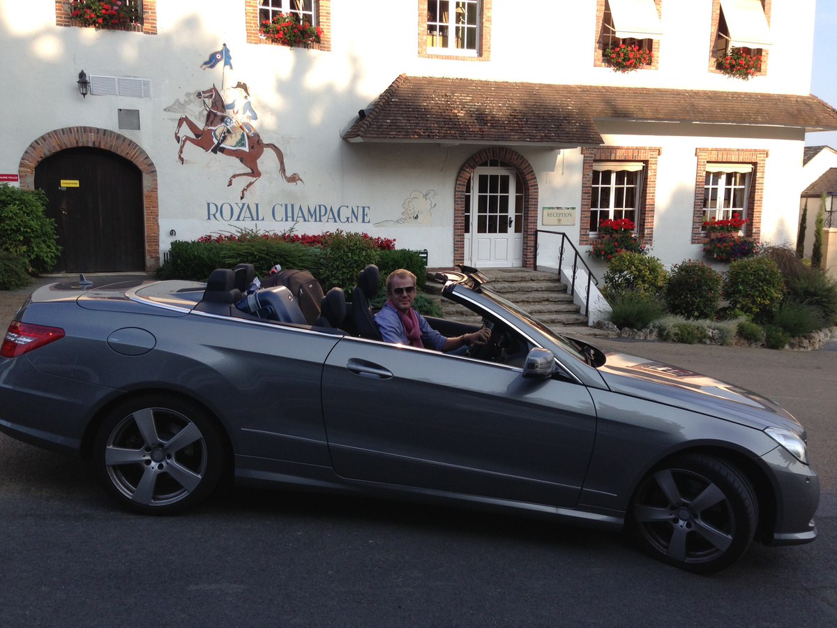 Konstantin in a silver convertible outside the earlier Royal Champagne building.