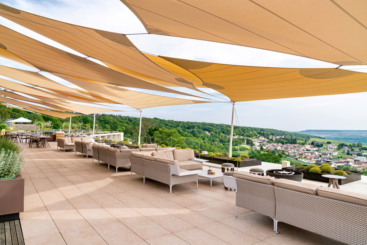 Shaded seating on Le Bellevue’s terrace overlooking Champillon and vineyards.