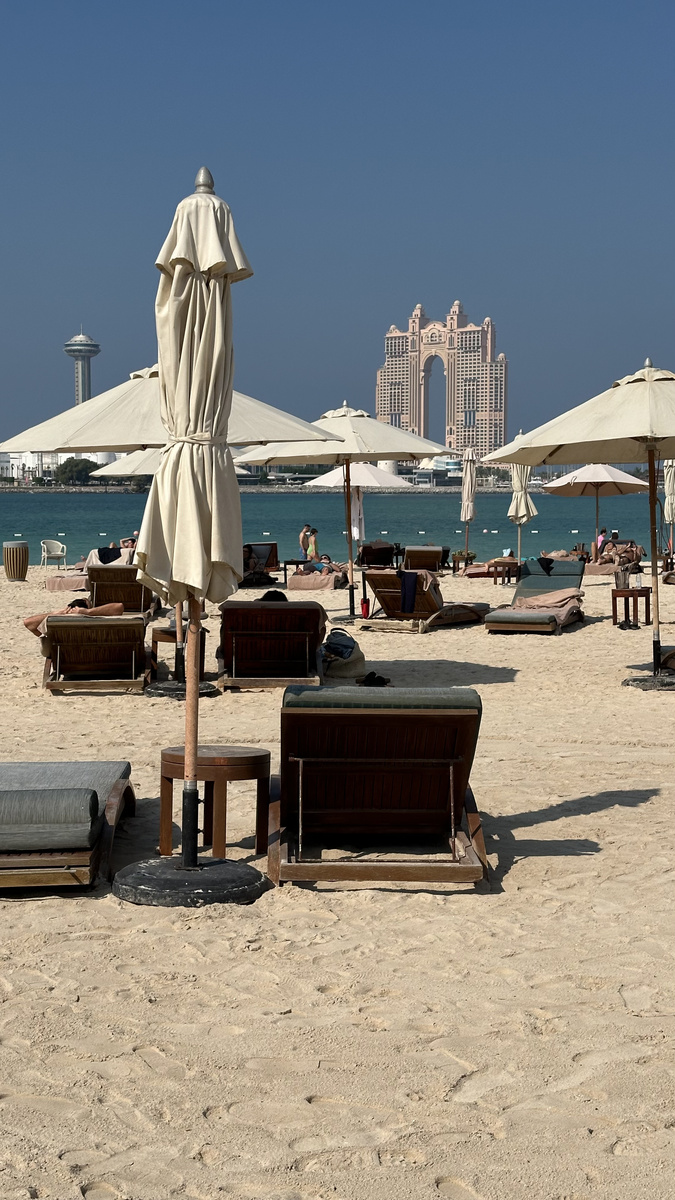 Sun loungers and umbrellas beside the water at Nation Riviera Beach Club.