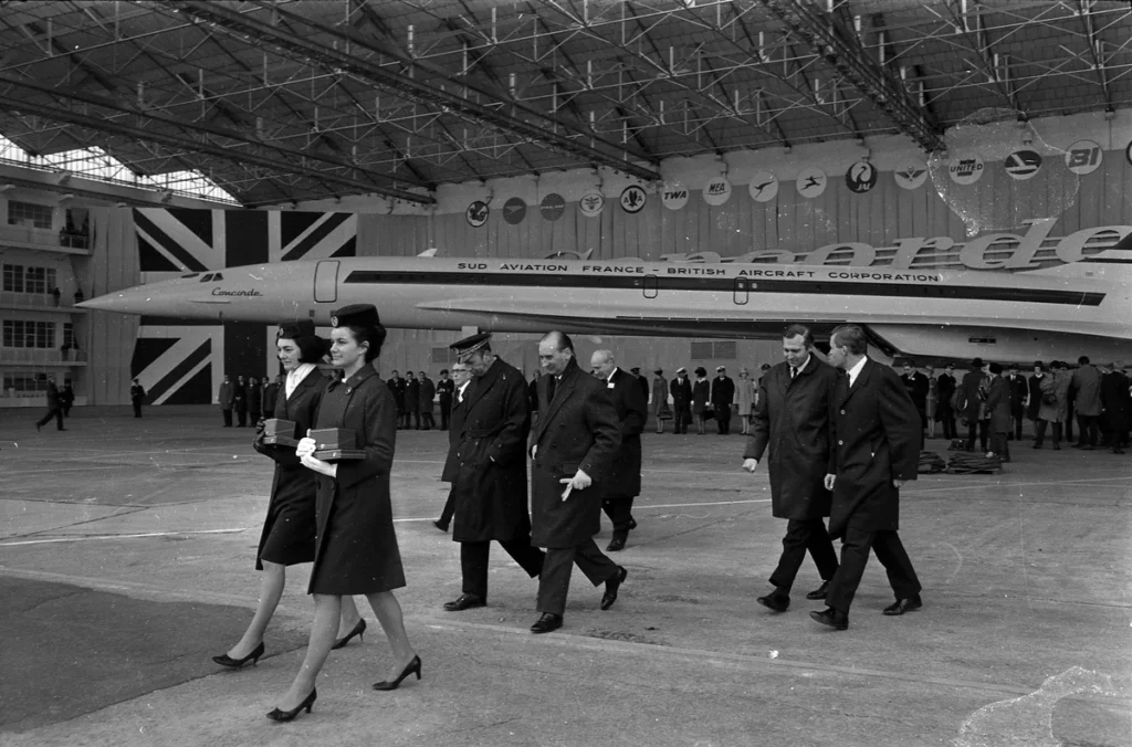 Tony Benn and other officials walk in front of Concorde 001 inside the Sud Aviation hangar at Toulouse in December 1967.