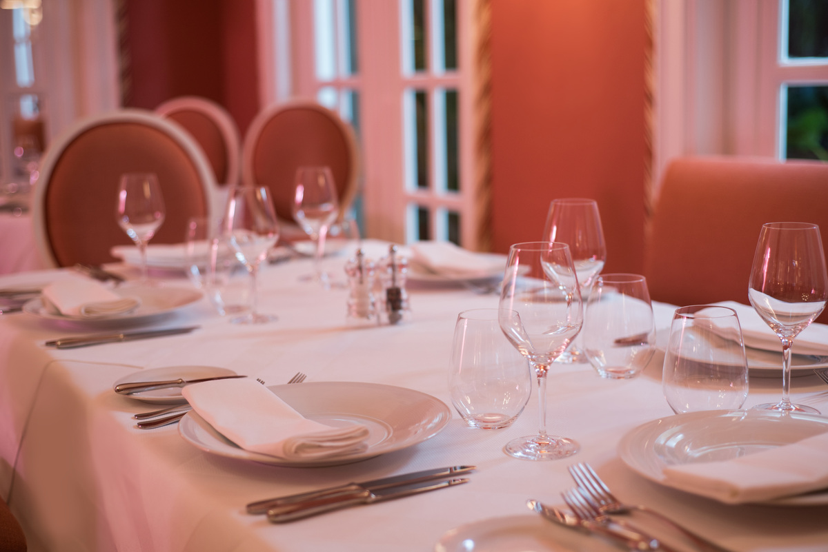 Glassware and pale table linen in Bamboo’s coral-coloured dining room.