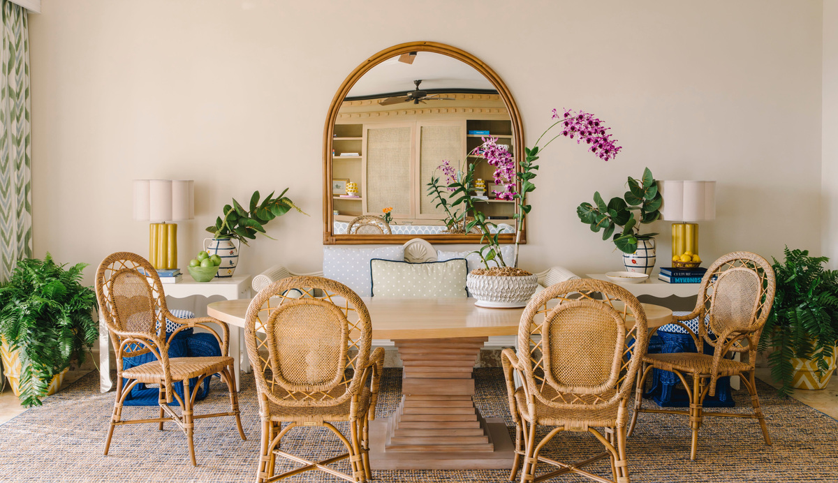 Round dining table, wicker chairs and a large mirror in a refreshed Tortuga Bay villa.