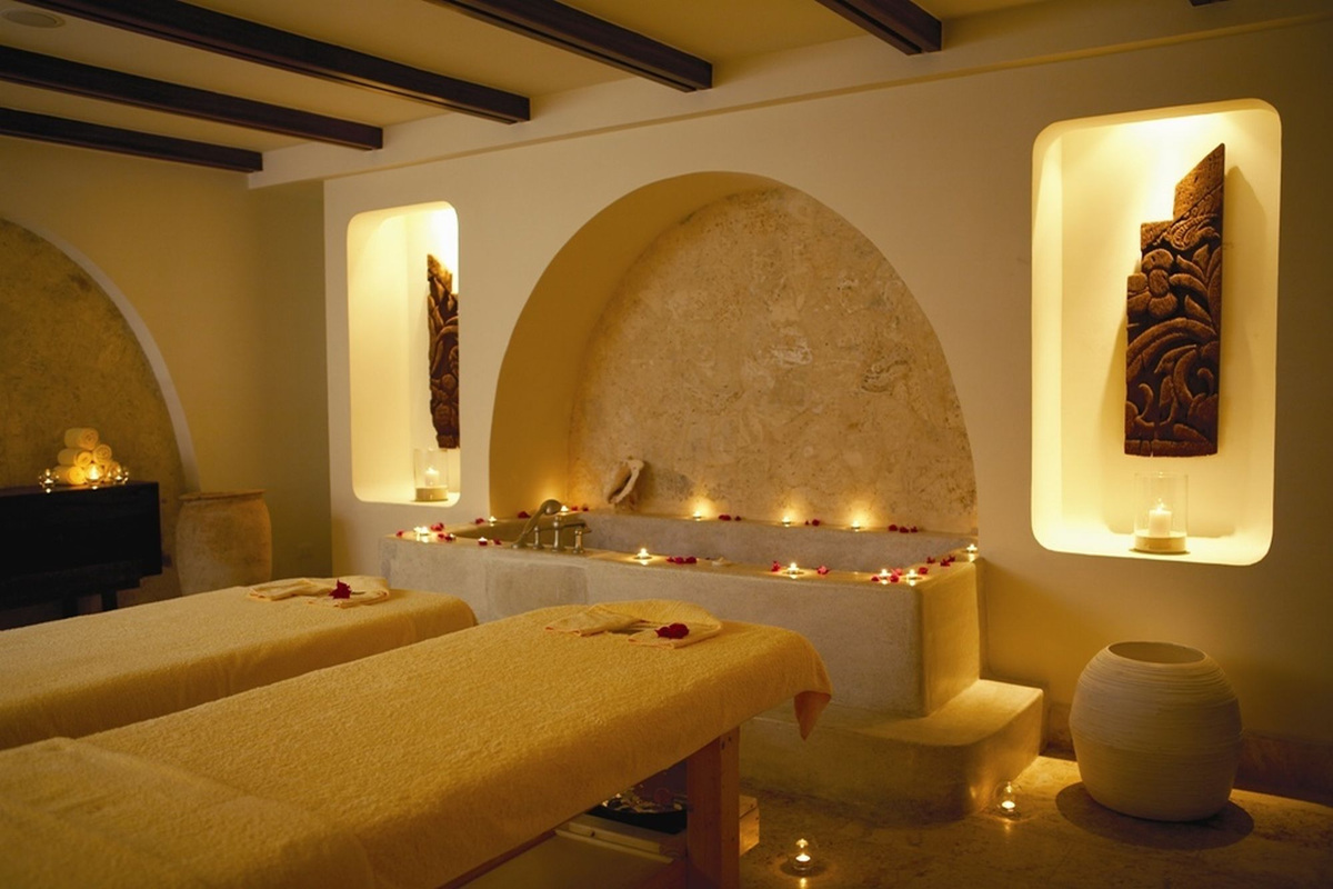 Two massage beds beside a candlelit bath in a treatment room at La Cana.