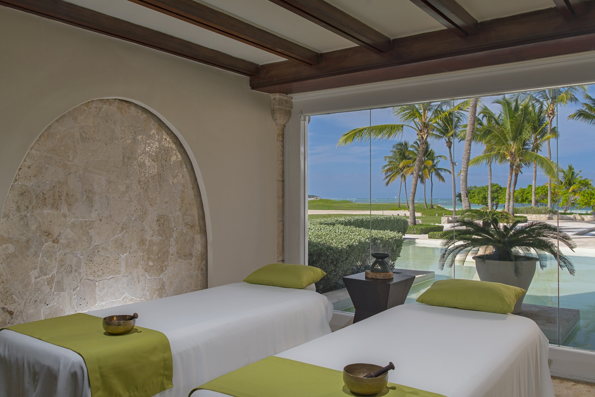 Two treatment beds facing the sea through an arched opening.
