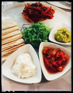 Small dishes, flatbread and vegetables on a table at Café SBG.