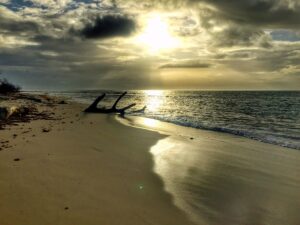 Low sunlight falls across a quiet island beach near Monte Cristi.