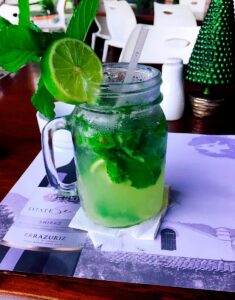 A green drink with lime in a glass jar at Noah Restaurant & Lounge.