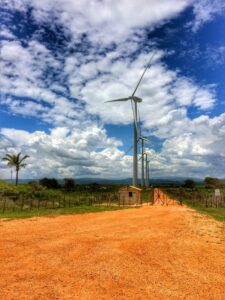 A wind turbine rises above reddish earth at Los Cocos wind farm.