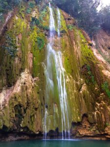 El Limón waterfall drops over a green rock face into a pool.