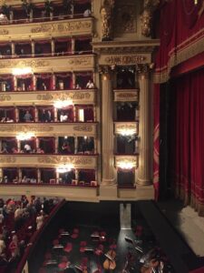 The tiers of boxes and red curtains inside La Scala opera house.