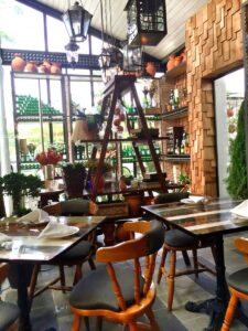 Tables, hanging lights and tall windows at Laurel Food and Wine.