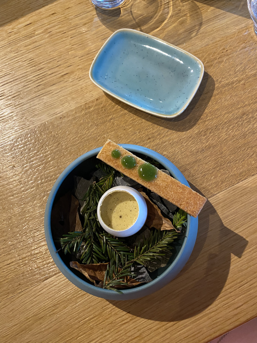 A small dinner course presented in a blue bowl at Les Cerniers.