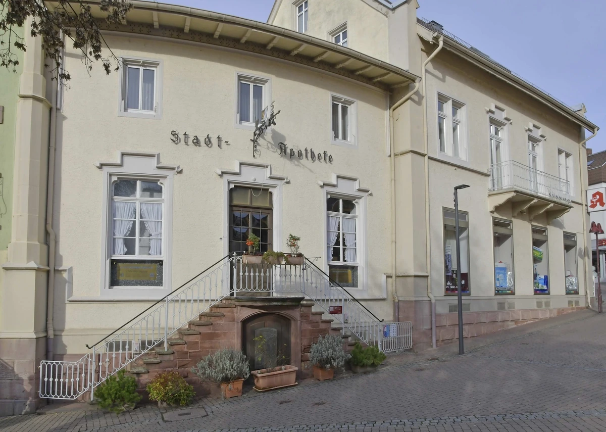 The Stadt-Apotheke’s cream façade, dark entrance door and double staircase in Wiesloch.