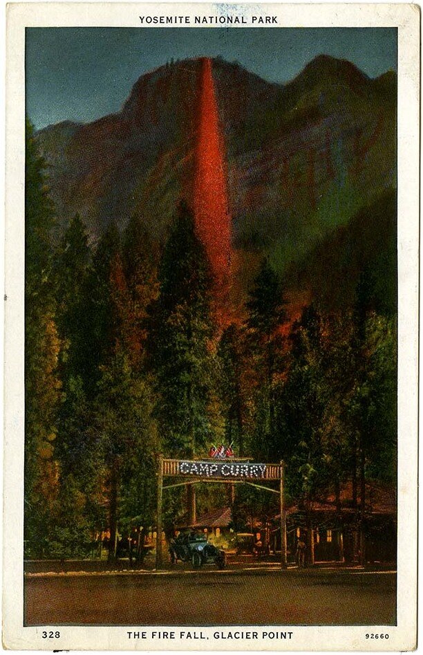 Postcard of a glowing red stream of fire pouring down a dark cliff above pines and a lit Camp Curry entrance sign.