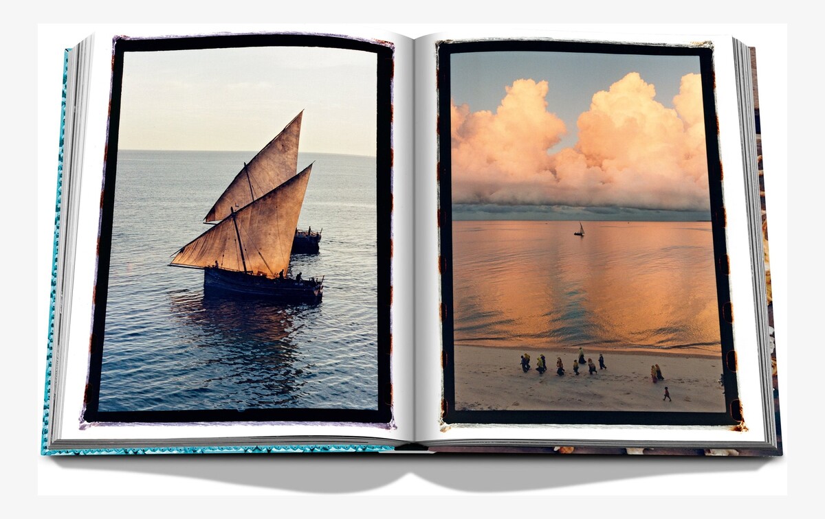 An open spread pairing a dhow under sail with a calm sea and golden evening clouds.