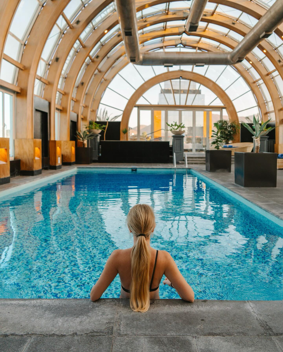 Olga at the indoor rooftop pool beneath the arched timber roof of The Ritz-Carlton Santiago.