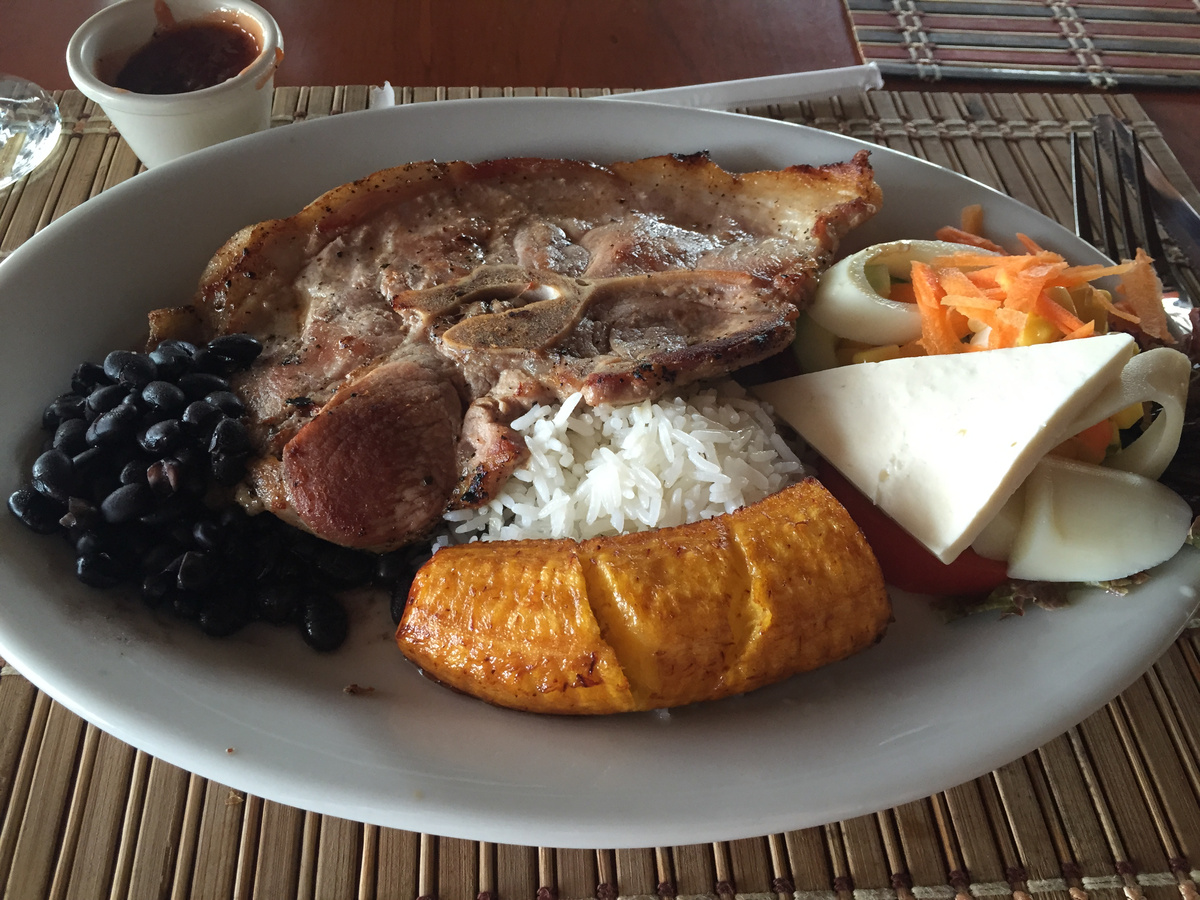 A plate of grilled meat, rice, black beans, fried plantain, cheese and salad at the lodge.