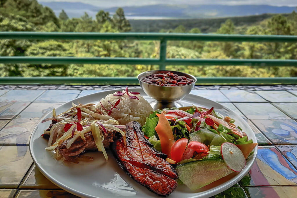 A Costa Rican meal with rice, beans, plantain, vegetables and meat on the restaurant terrace.