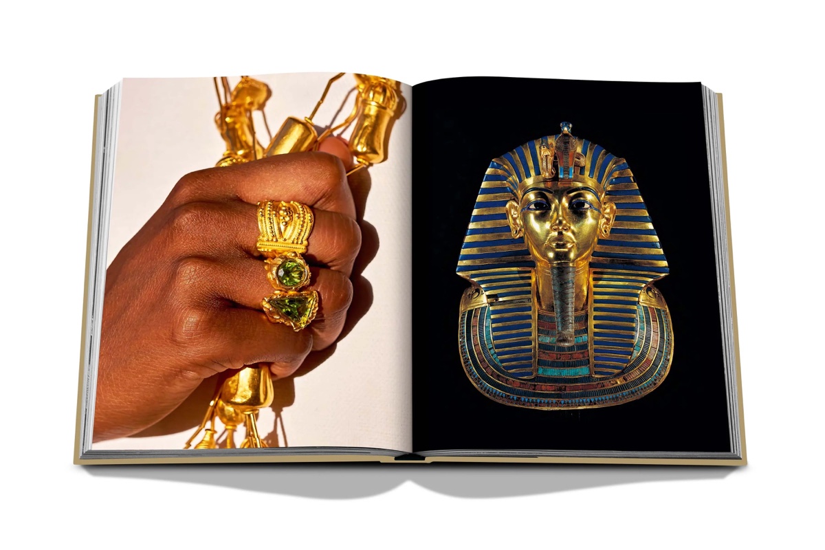 An open spread from Cairo Eternal: a hand wearing gold rings set with green stones, facing Tutankhamun’s gold funerary mask on black.