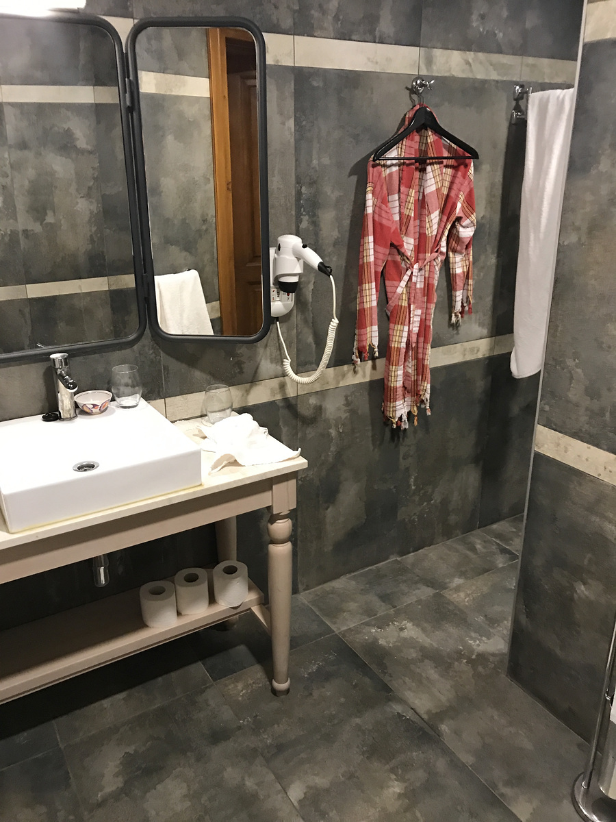 A washbasin, mirrors, hairdryer, bathrobe and towels in our Char Me bathroom.