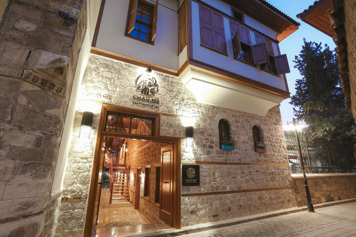 Char Me Boutique Hotel’s illuminated stone façade, wooden upper floor and entrance on Zafer Sokak.
