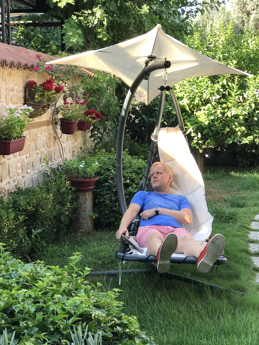 Kostya relaxing in a suspended garden lounger at Char Me Boutique Hotel.