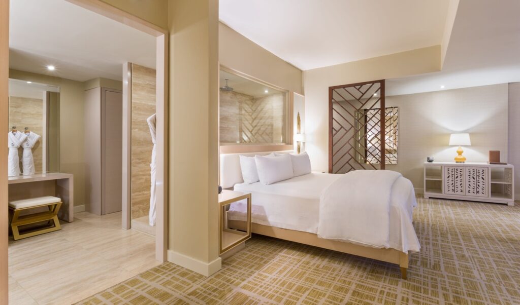 King bed beside a marble bathroom in a Condo Suite at Waldorf Astoria Panama.