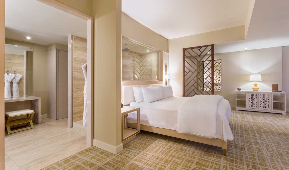 King bed beside a marble bathroom in a Condo Suite at Waldorf Astoria Panama.