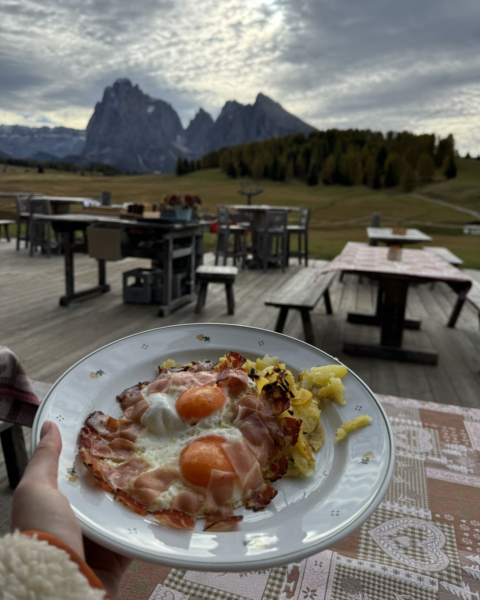Eggs served on the terrace at Malga Sanon, with the Dolomite mountains beyond.