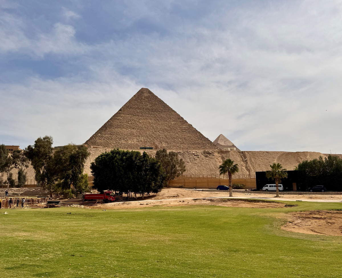 The Great Pyramid above worn turf and sandy areas on the Mena House golf grounds in RTJ II’s May 2026 photograph.